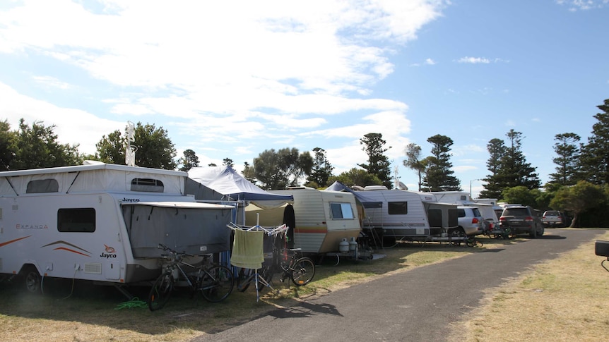 A row of caravans at a caravan park in summertime.
