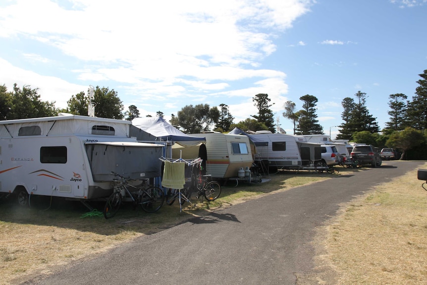 A row of caravans at a caravan park in summertime.