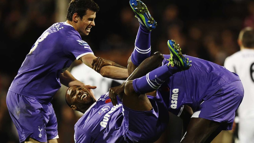 Defoe is upended by Bale and Adebayor after scoring against Fulham