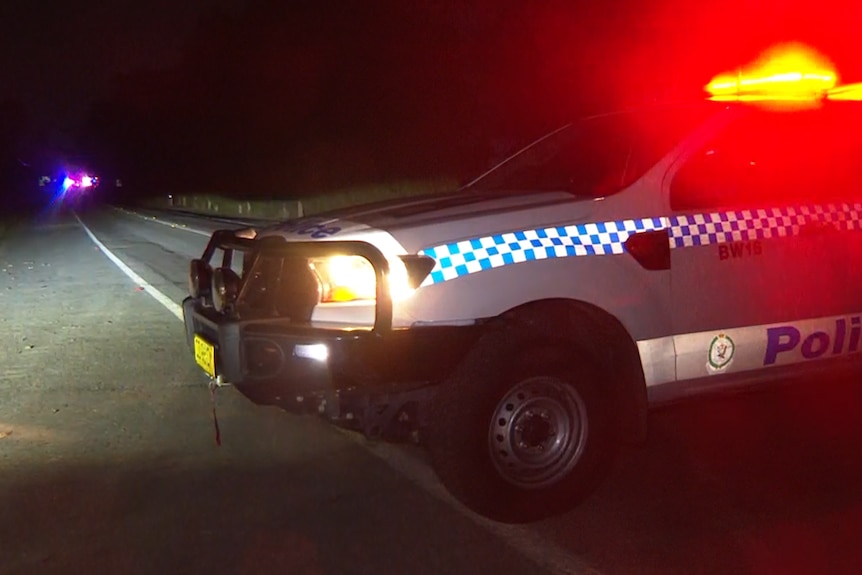 Police vehicles with lights blaring in the night.