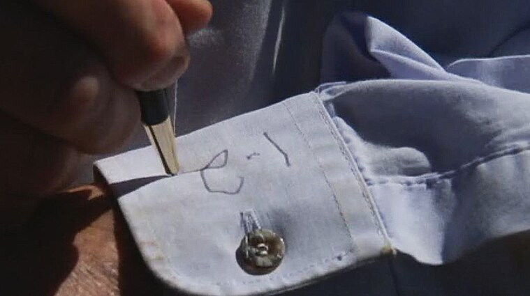 Peter Jones writes a rainfall measurement on his shirt cuff.