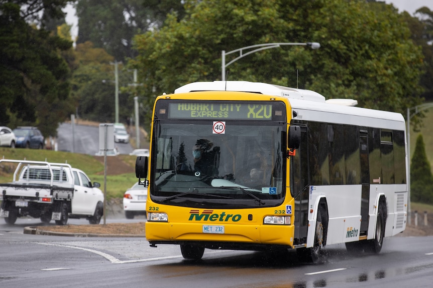 A Metro bus displaying the text "Hobart city express" on the front, driving along a road