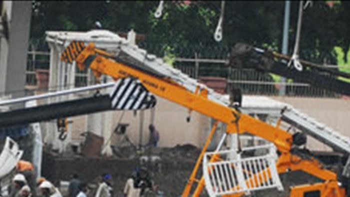 Cranes remove debris of a collapsed bridge