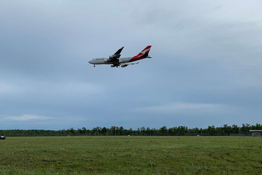 A Qantas p[lane carrying coronavirus evacuees descends into Darwin.