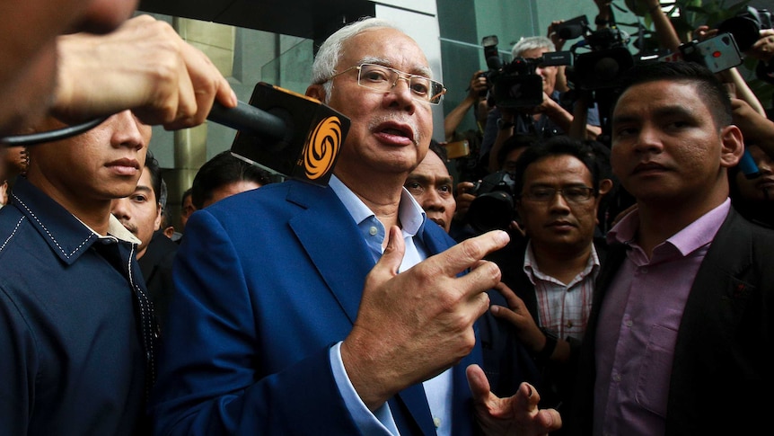 Najib Razak surrounded by reporters