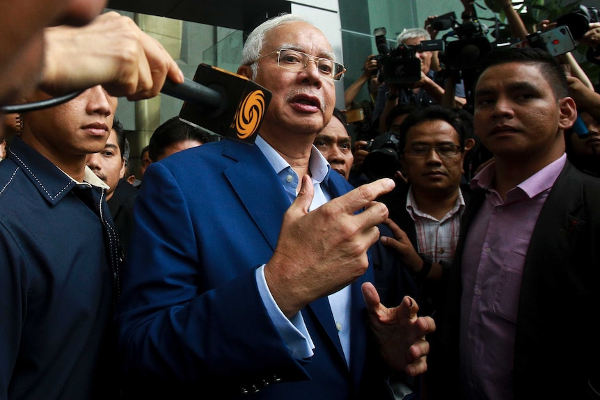 Najib Razak surrounded by reporters
