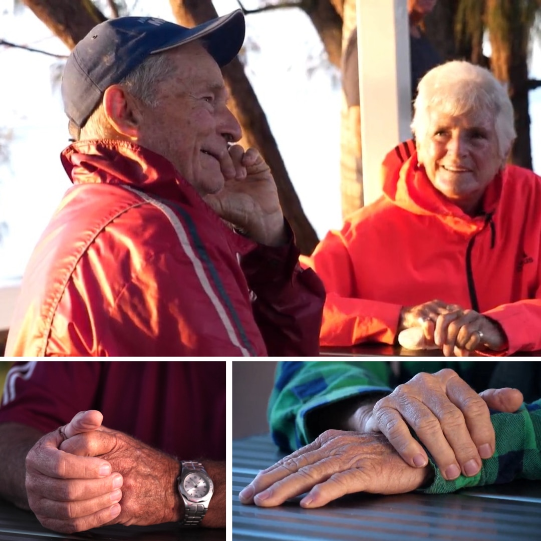 Dos personas riendo y fotografías de manos sobre una mesa.
