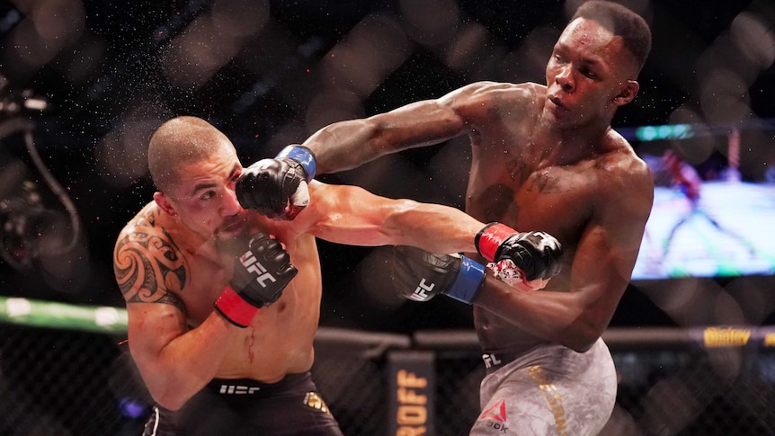 Robert Whittaker gets punched in the head by Israel Adesanya