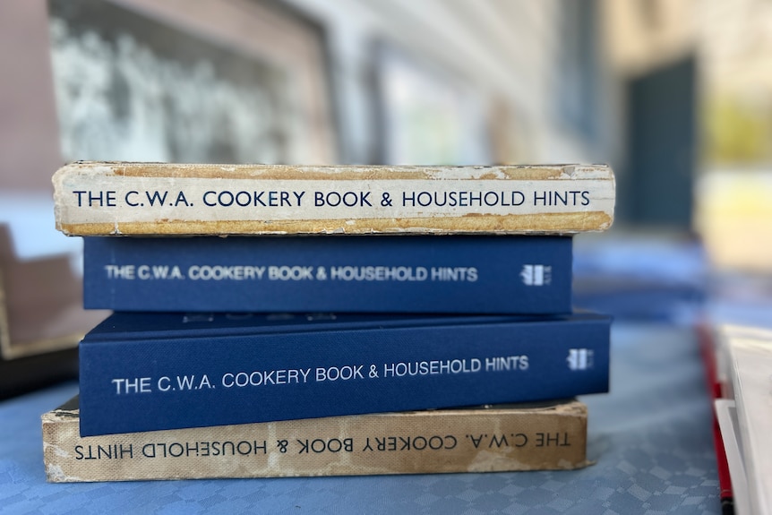 A pile of four CWA cookbooks.