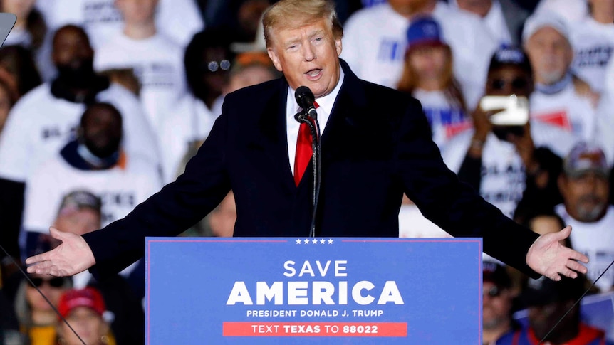 Donald Trump puts his arms out to his side as he speaks to supporters at a rally in Conroe, Texas