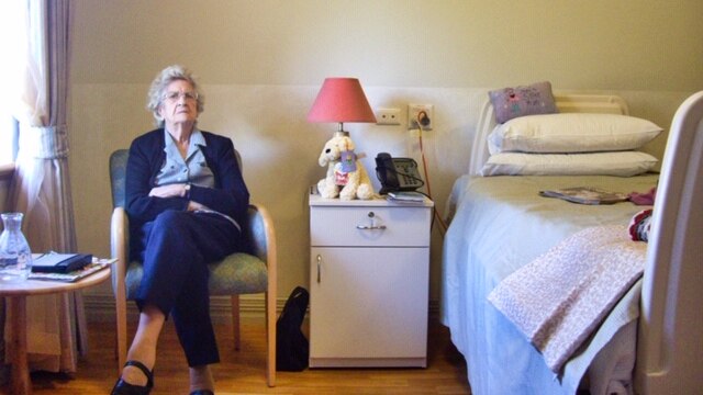 An older woman in a nursing home looking confused.
