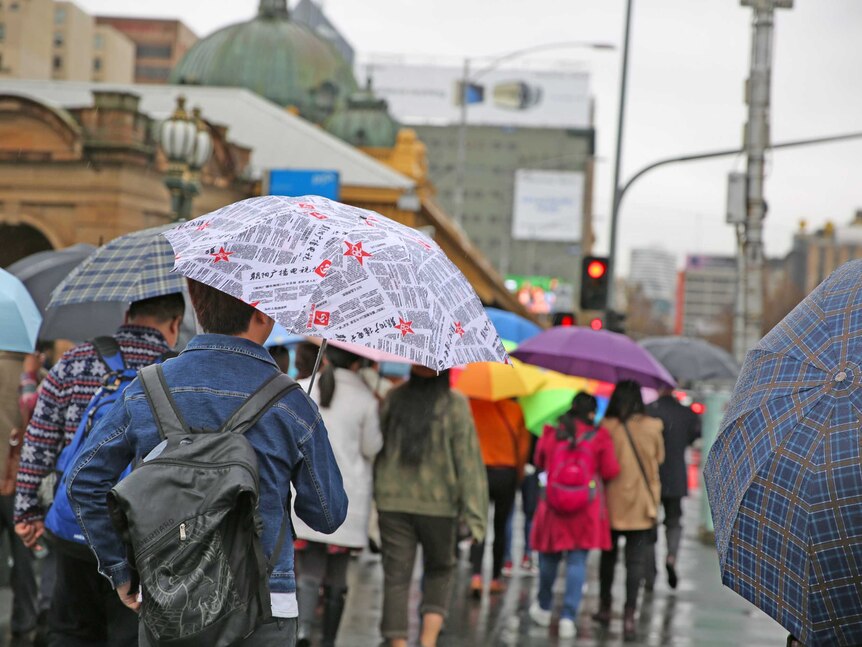 People walking under umbrellas in Melbourne.