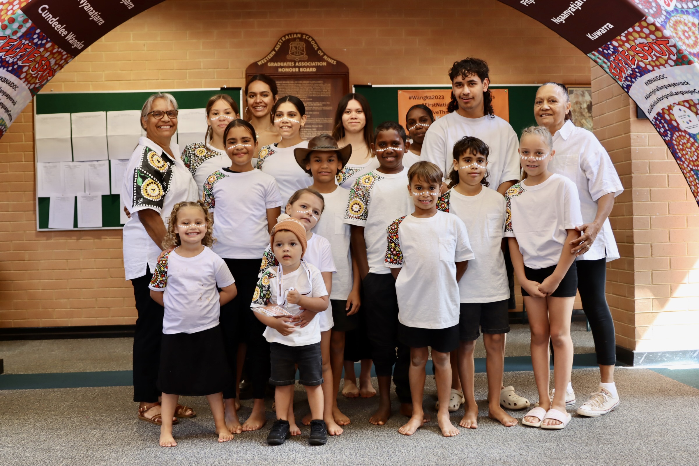 group of Aboriginal children wearing hand-painted shirts. 