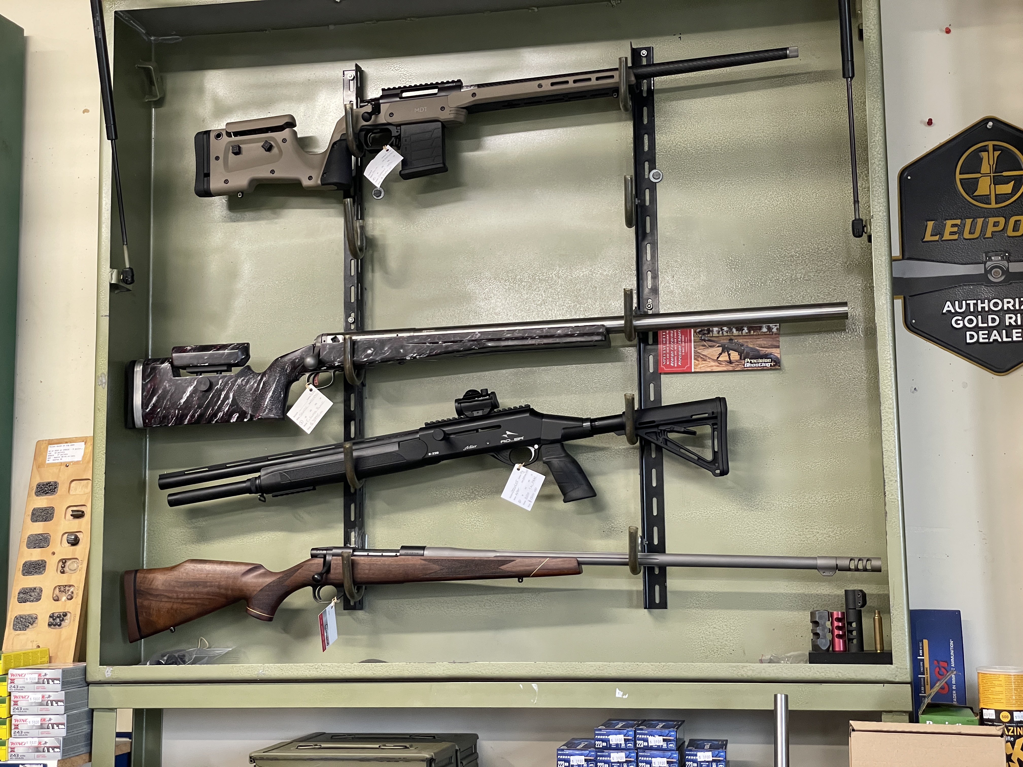 Bolt action rifles on display in a firearms store, identical function but are cosmetically different