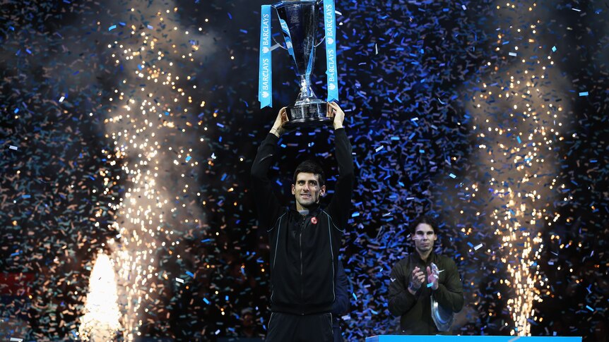 Novak Djokovic lifts the World Tour Finals trophy after beating Rafael Nadal in the final.