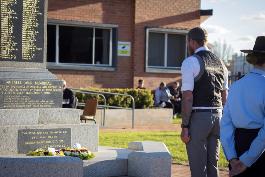 A young man stands to attention after laying a wreath at the Inverell cenotaph