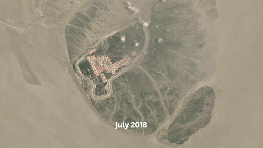 A satellite image showing roads and red roofs of houses appearing on a small island