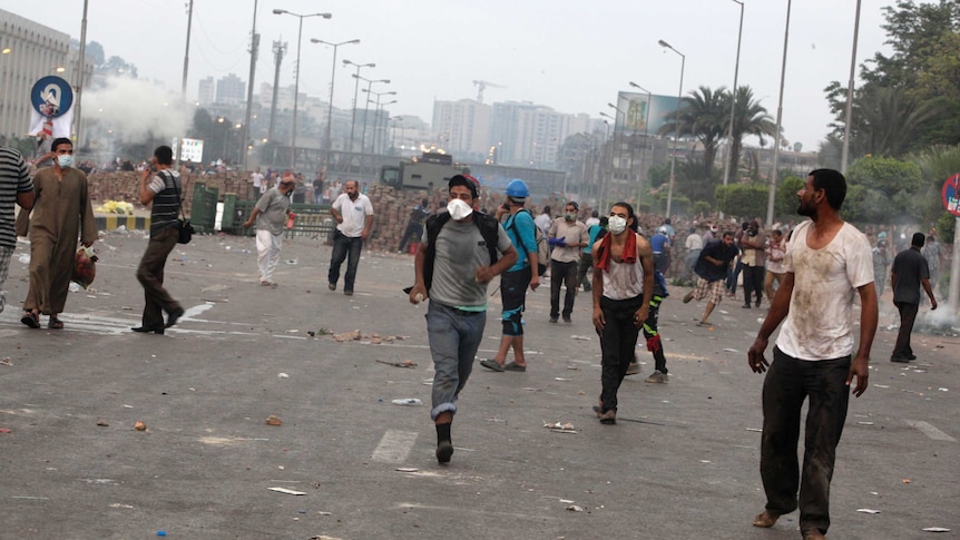Morsi supporters in Cairo run from tear gas thrown by police