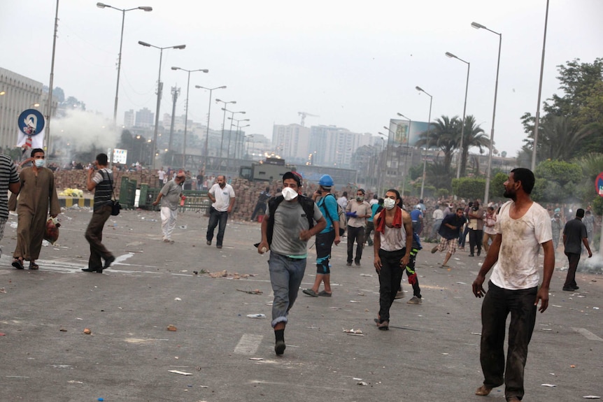 Morsi supporters in Cairo run from tear gas thrown by police