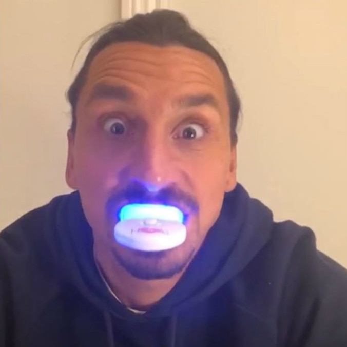 Zlatan Ibrahimovic, wearing a hoodie, looks at the camera with a teeth-whitening mouthguard in his mouth.