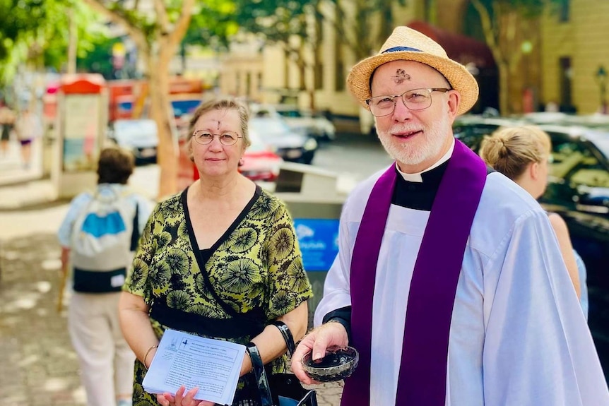 A reverend and a helper outside a church when social distancing was not an issue.