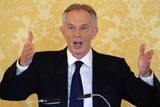 Former British prime minister Tony Blair gestures while delivering a speech.