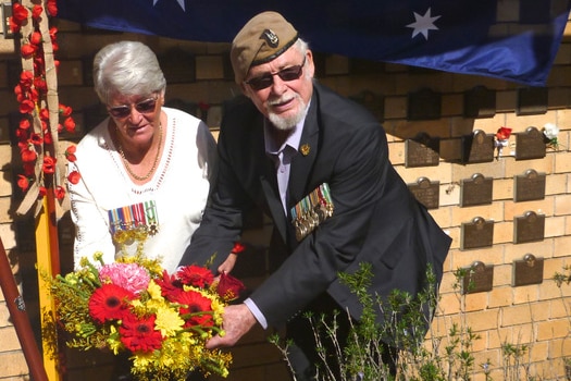 Man and woman holding a wreath.