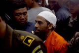 Umar Patek arrives under police escort at a West Jakarta court