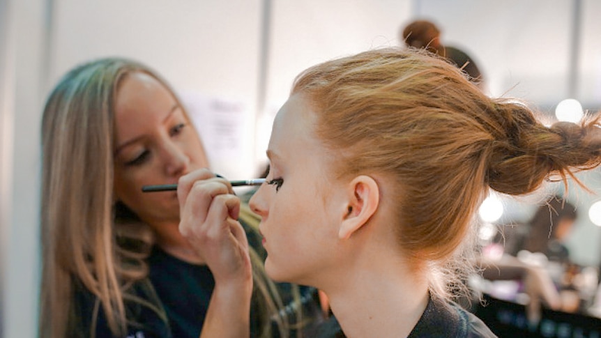 Nicole Bratis applies eye make-up to a model at Fashion Week Australia.