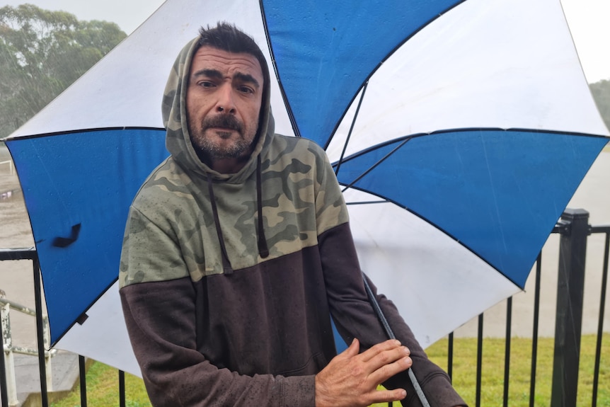 a man standing holding an umbrella