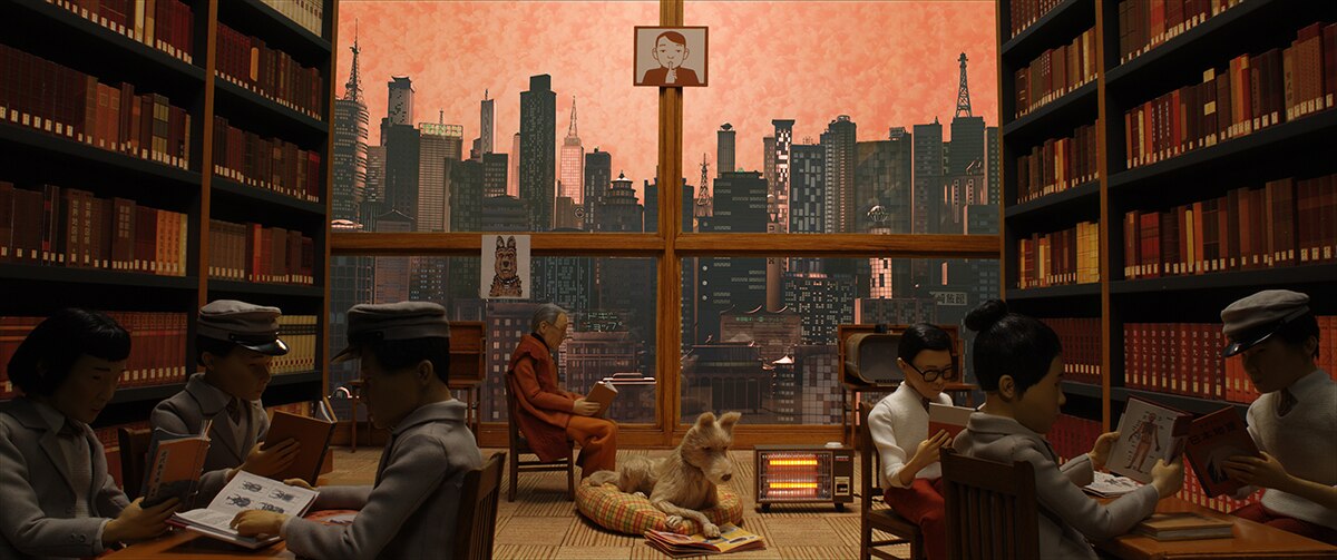 Colour still of a dog and it's owner reading inside a library in Megasaki City in stop-motion animation Isle of Dogs.