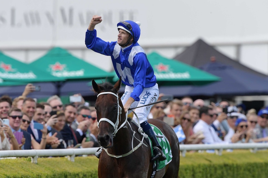 Hugh Bowman pumps his right fist as returns Winx to scale at Royal Randwick.