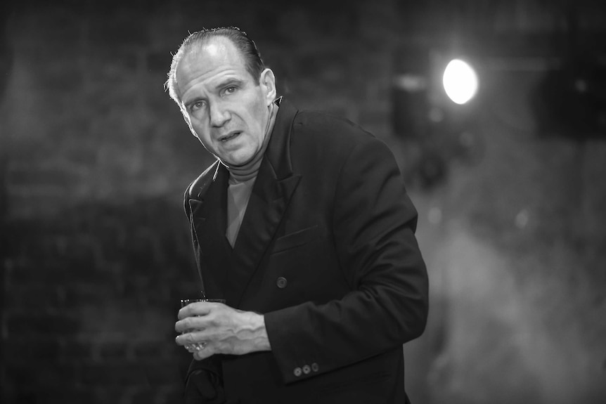 Black and white image of Ralph Fiennes performing as Richard III with a distinctly hunched back.