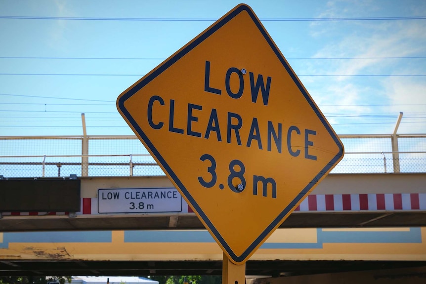 Low clearance bridge sign in foreground with bridge in background