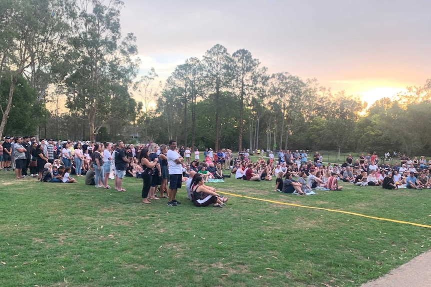 A group of people sitting on a grassy area