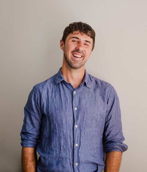 Psychologist and author Chris Cheers smiling. He is wearing a blue button down shirt.