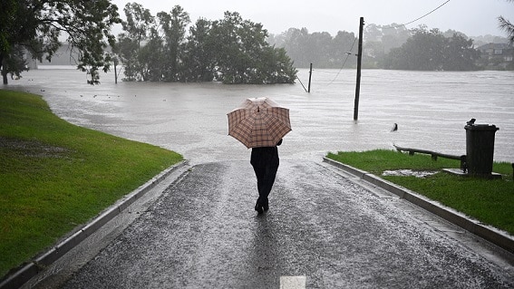 A man with his umbrella faces flood