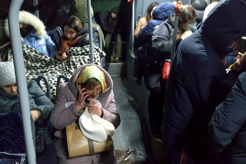 People sit inside a but waiting to be evacuated to Russia.