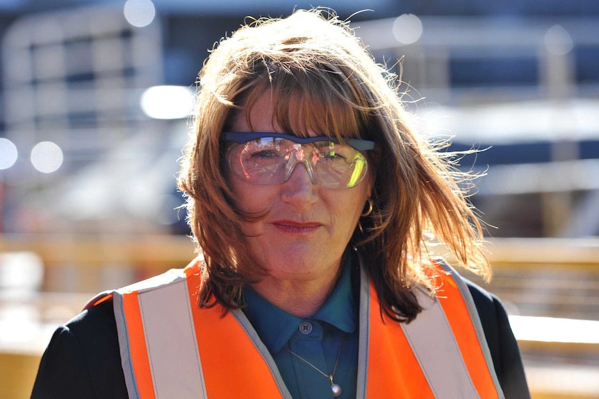 Labor's Joanne Ryan wears an orange vest and safety glasses as she campaigns at One Steel.