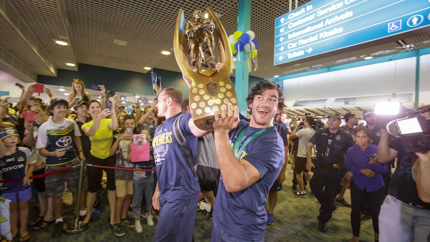 Cowboys co-captains Matt Scott and Johnathan Thurston hold the NRL premiership trophy aloft in Townsville Airport