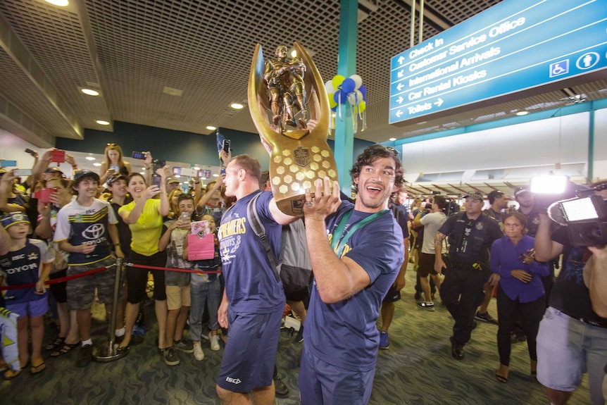 Cowboys co-captains Matt Scott and Johnathan Thurston hold the NRL premiership trophy aloft in Townsville Airport