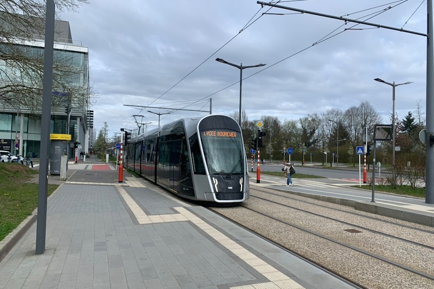 A tram driving though an empty street in Luxembourg. 