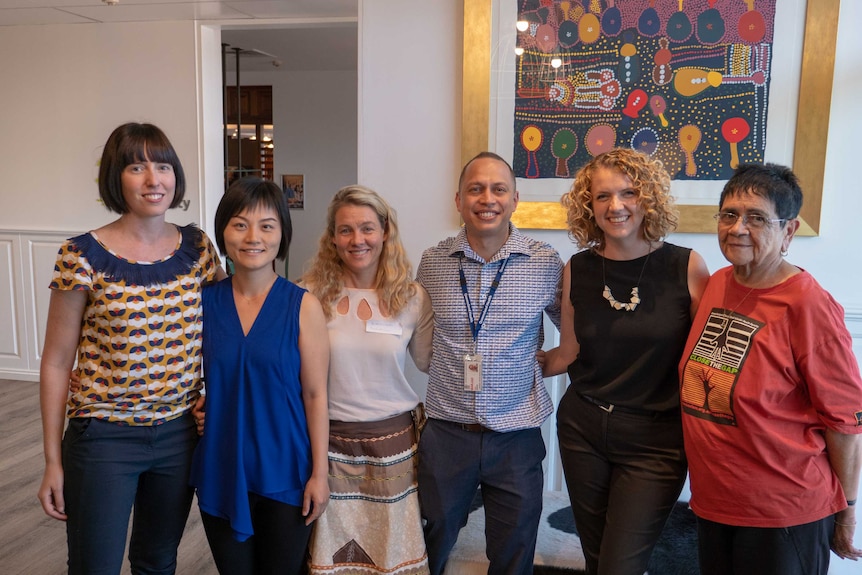 A group shot of people standing together in professional workwear.