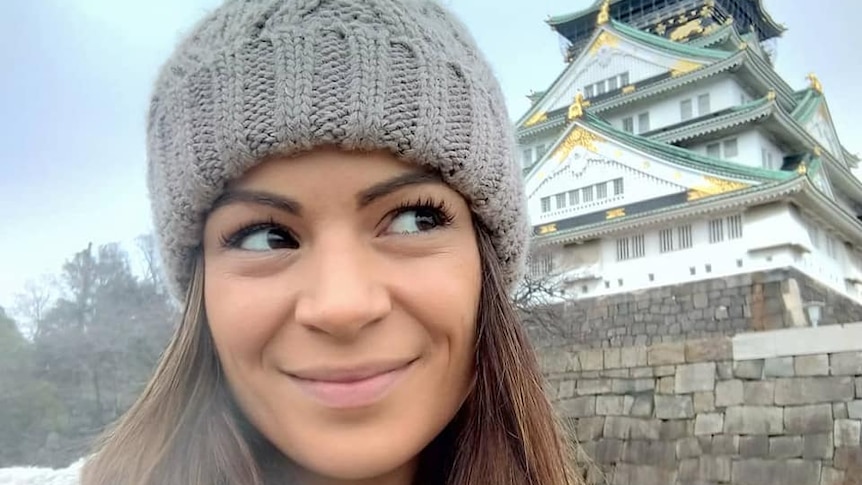 Australian Rina Laino next to a building in Japan.