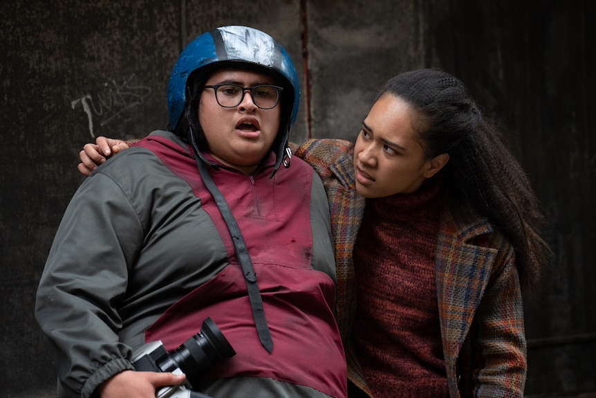 Julian Dennison in Uproar, being comforted by his friend (played by Jada Fa'atui), wearing a protective helmet.