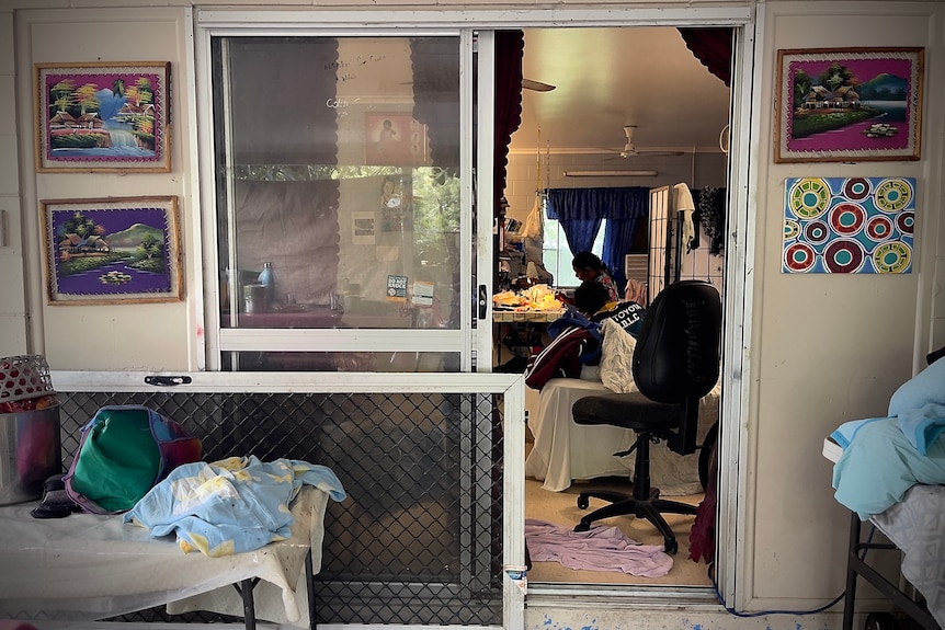 A broken screen door is lying on its side outside the front entrance to the Cedric family's home.