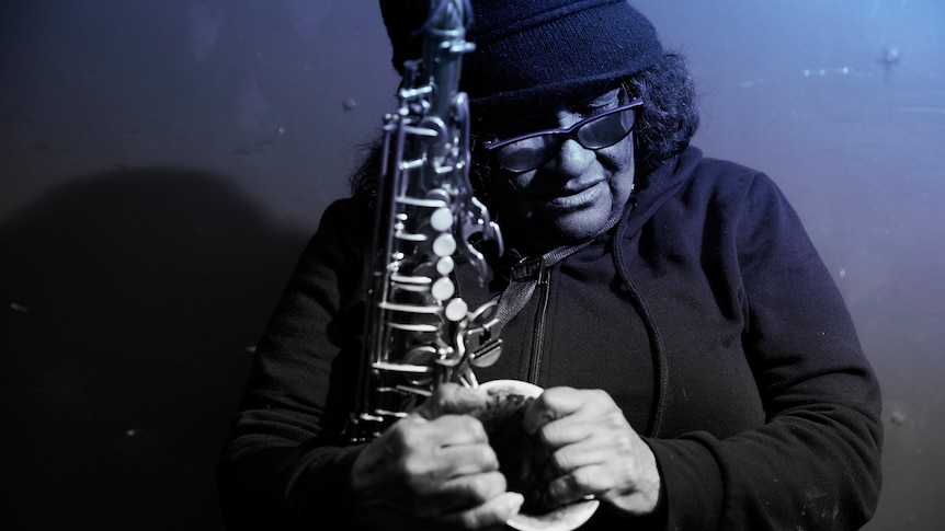 Black and white photo of Marlene Cummins holding saxophone