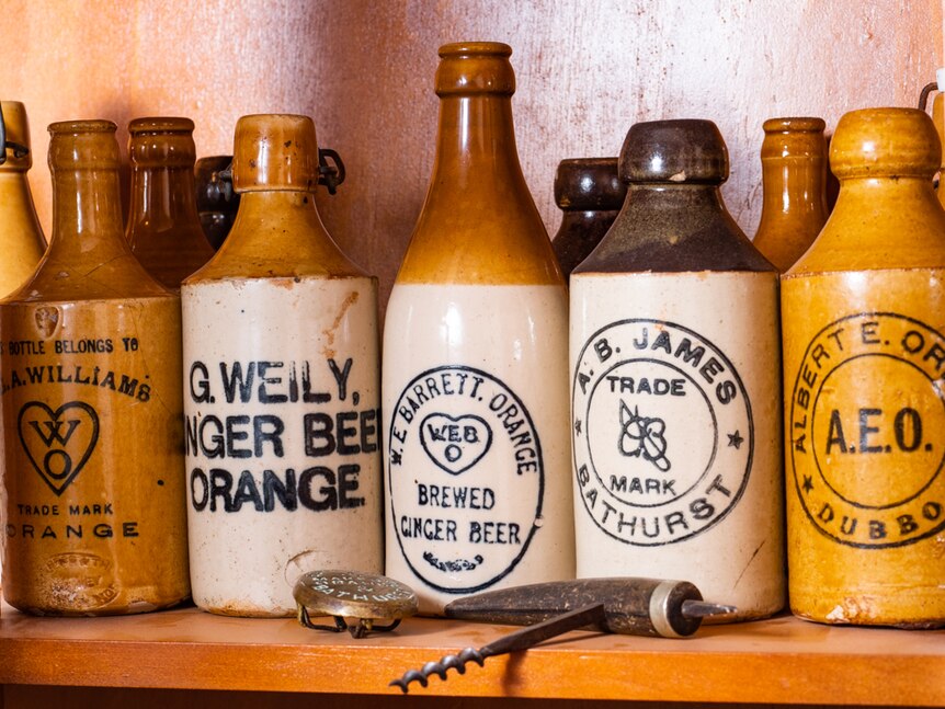 Historic ginger beer bottles from displayed on a shelf.