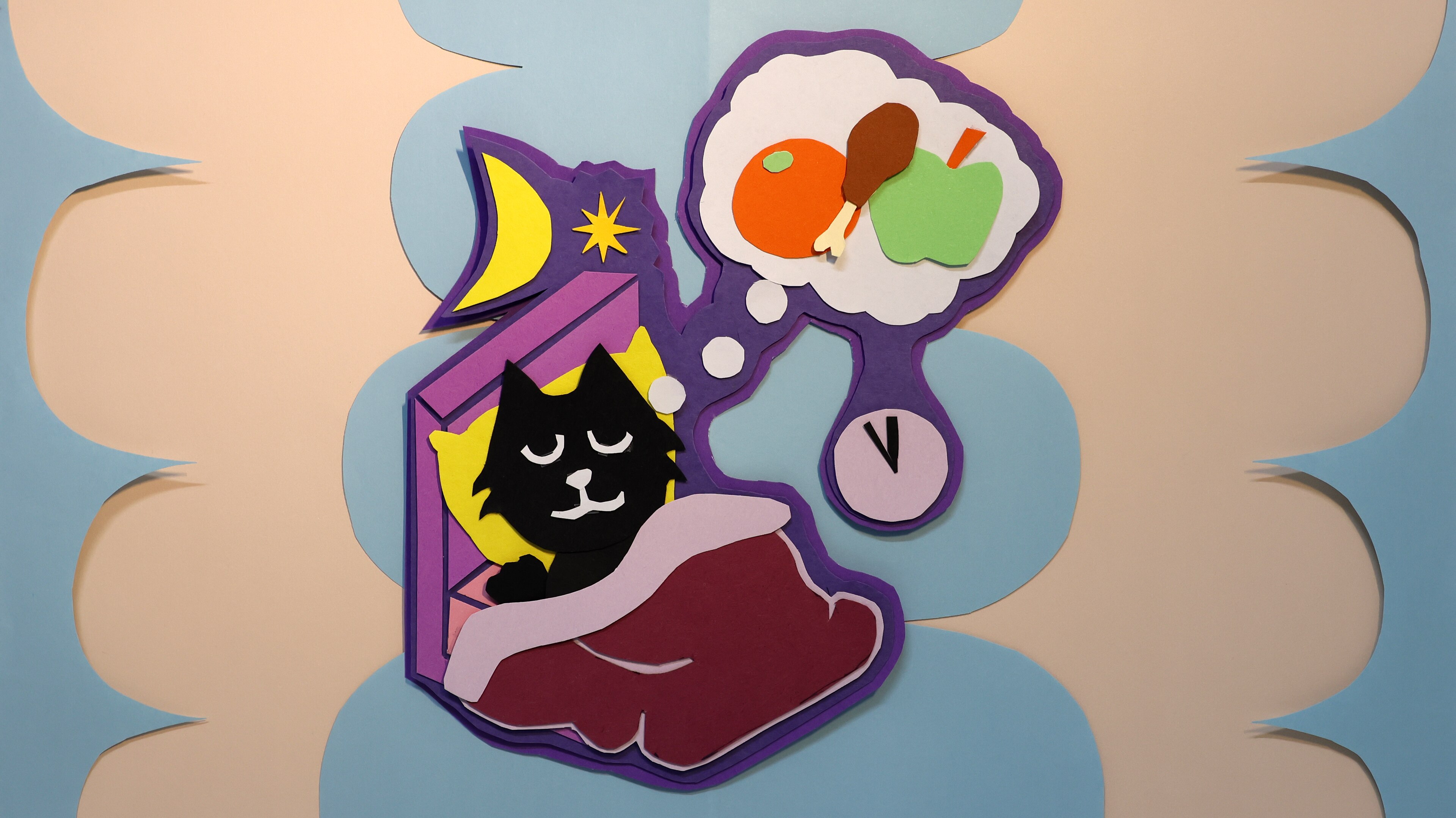 An artwork showing a black cat in a bedwith a thought bubble showing an orange, drumstick and apple.