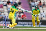Steve Smith batting on a pitch in a green and gold Australian uniform